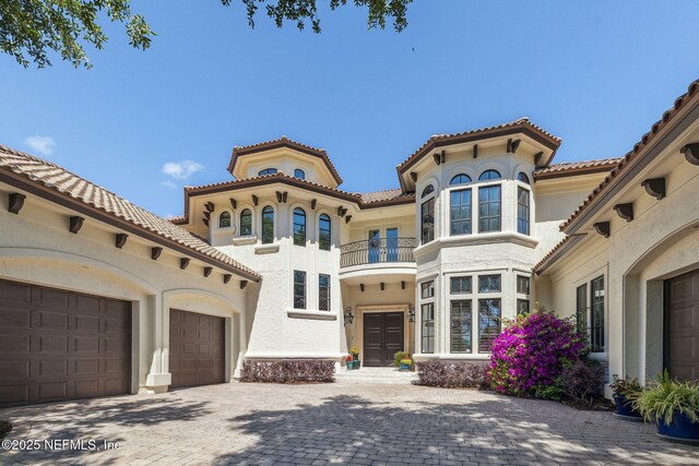 108 Harbourmaster Ct, Ponte Vedra Beach, FL 32082 - view of front of house with a balcony, a garage, stucco siding, a tiled roof, and french doors