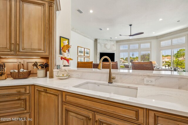108 Harbourmaster Ct, Ponte Vedra Beach, FL 32082 - kitchen featuring a sink, open floor plan, light stone counters, brown cabinets, and a ceiling fan
