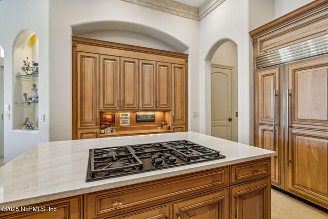 108 Harbourmaster Ct, Ponte Vedra Beach, FL 32082 - kitchen with black gas cooktop, paneled built in fridge, light stone countertops, and brown cabinetry