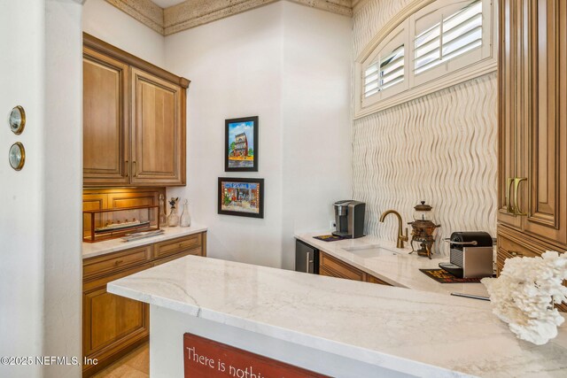 108 Harbourmaster Ct, Ponte Vedra Beach, FL 32082 - kitchen with a sink, light stone counters, and brown cabinetry