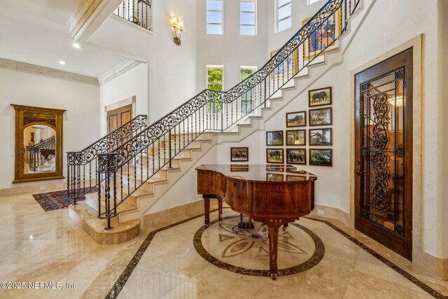 108 Harbourmaster Ct, Ponte Vedra Beach, FL 32082 - staircase featuring a towering ceiling, inlaid floor details, baseboards, crown molding, and recessed lighting
