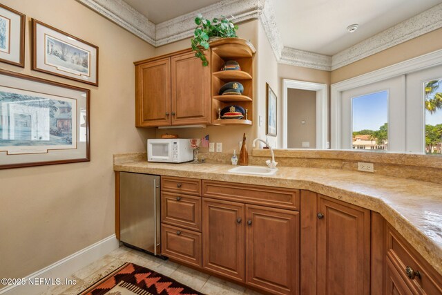 108 Harbourmaster Ct, Ponte Vedra Beach, FL 32082 - kitchen with white microwave, a sink, refrigerator, baseboards, and brown cabinets