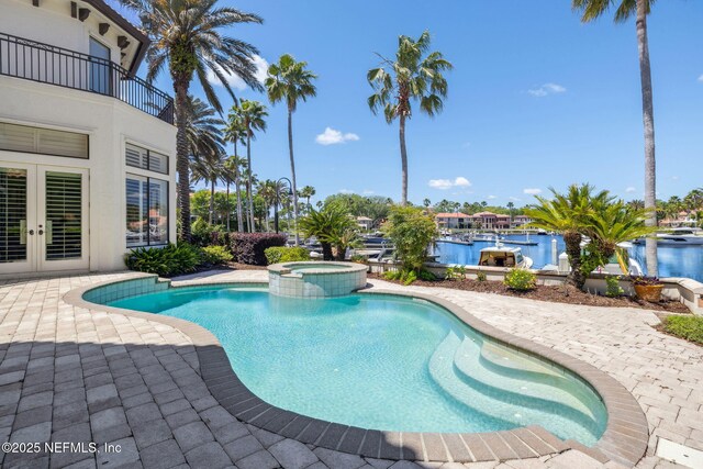 108 Harbourmaster Ct, Ponte Vedra Beach, FL 32082 - view of swimming pool with french doors, a patio area, a pool with connected hot tub, and a water view