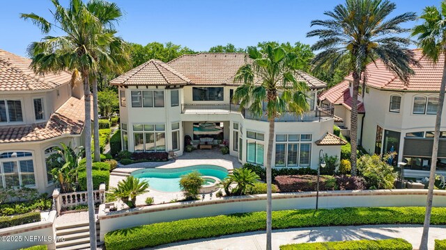 108 Harbourmaster Ct, Ponte Vedra Beach, FL 32082 - back of property with stucco siding, a pool with connected hot tub, a tile roof, a patio area, and a balcony