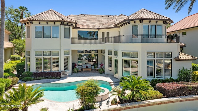 108 Harbourmaster Ct, Ponte Vedra Beach, FL 32082 - rear view of house with a balcony, stucco siding, a tiled roof, a patio, and a pool with connected hot tub