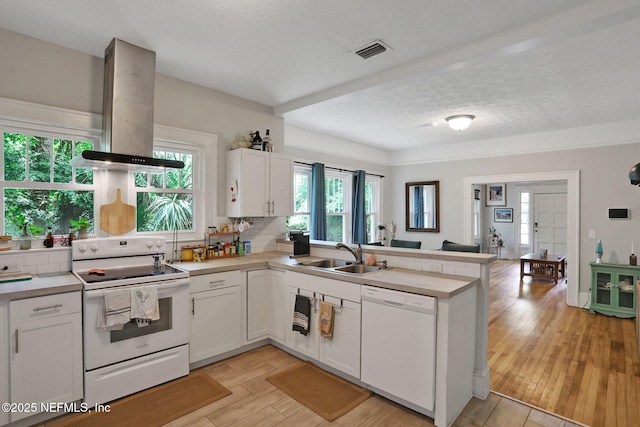 kitchen featuring white cabinets, a sink, white appliances, a peninsula, and island range hood