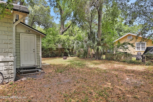 view of yard featuring a fenced backyard, an outbuilding, and a storage shed