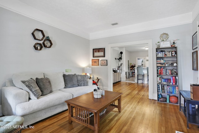 living area featuring baseboards, visible vents, and light wood-style floors