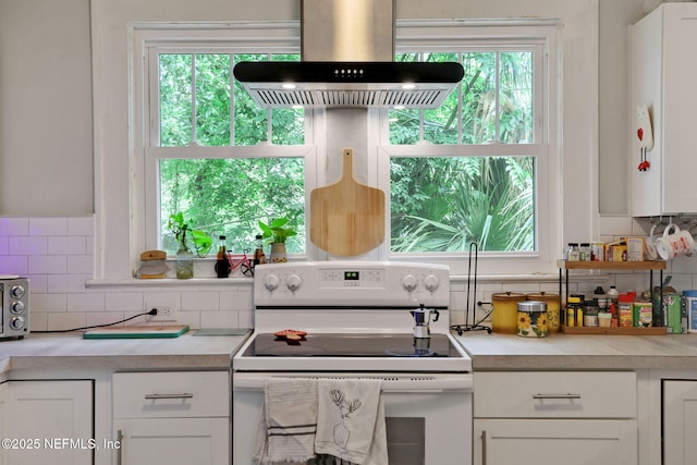 kitchen featuring light countertops, white range with electric cooktop, white cabinetry, and island range hood