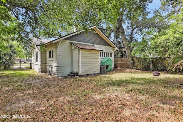 rear view of property with a yard, cooling unit, and a fenced backyard