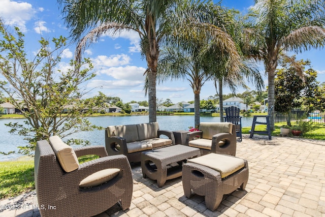 view of patio / terrace with a water view, outdoor lounge area, and fence