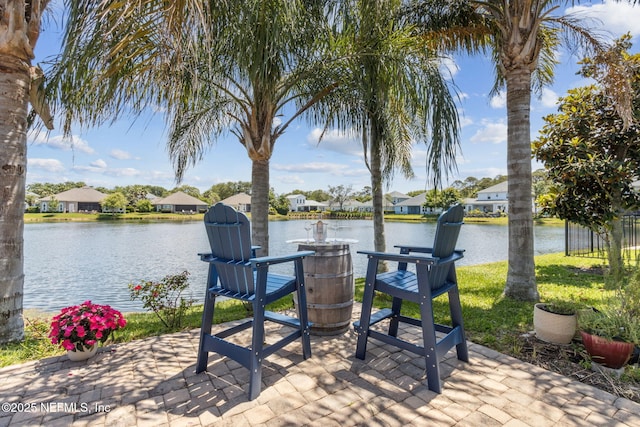 view of patio / terrace with a residential view and a water view