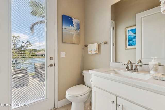 bathroom featuring vanity, baseboards, and toilet