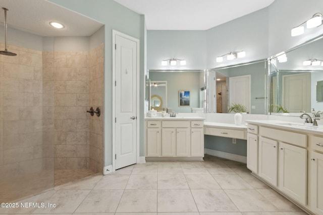 bathroom with tile patterned flooring, a sink, a walk in shower, and two vanities