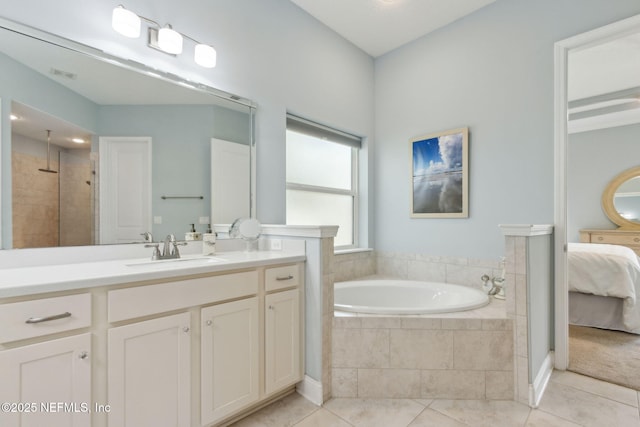 ensuite bathroom with ensuite bathroom, a bath, tile patterned floors, and vanity