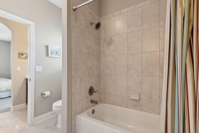 bathroom with toilet, tile patterned floors, baseboards, and shower / bath combo