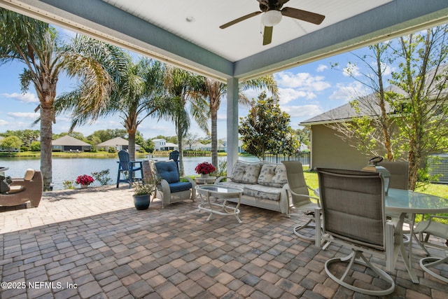 view of patio / terrace with outdoor dining area, a water view, an outdoor living space, and ceiling fan