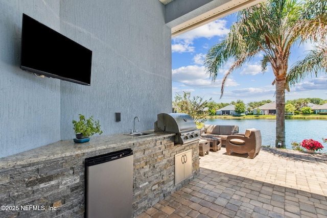 view of patio featuring area for grilling, a water view, a sink, and a grill