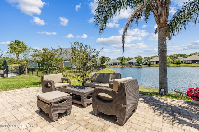 view of patio featuring fence, a water view, an outdoor living space, and a residential view