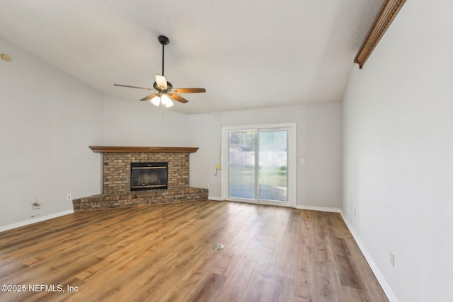 6085 Bermuda Dr, Fleming Island, FL 32003 - unfurnished living room with a ceiling fan, wood finished floors, a fireplace, lofted ceiling, and baseboards