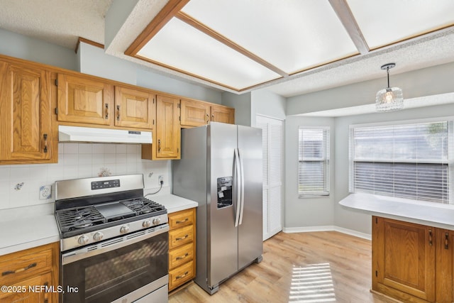 6085 Bermuda Dr, Fleming Island, FL 32003 - kitchen featuring appliances with stainless steel finishes, under cabinet range hood, light wood finished floors, and light countertops