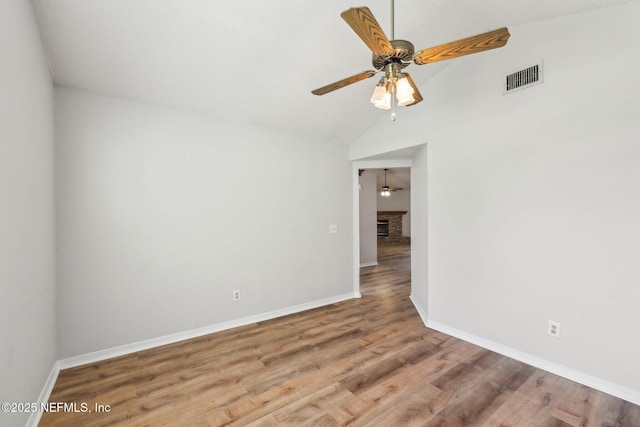 6085 Bermuda Dr, Fleming Island, FL 32003 - unfurnished room featuring ceiling fan, baseboards, wood finished floors, vaulted ceiling, and a fireplace