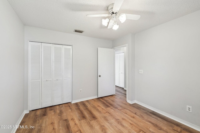 6085 Bermuda Dr, Fleming Island, FL 32003 - unfurnished bedroom featuring wood finished floors, a closet, baseboards, a textured ceiling, and a ceiling fan