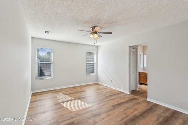 6085 Bermuda Dr, Fleming Island, FL 32003 - unfurnished room featuring a ceiling fan, wood finished floors, a textured ceiling, and baseboards