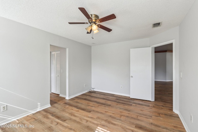6085 Bermuda Dr, Fleming Island, FL 32003 - empty room with ceiling fan, wood finished floors, baseboards, and a textured ceiling
