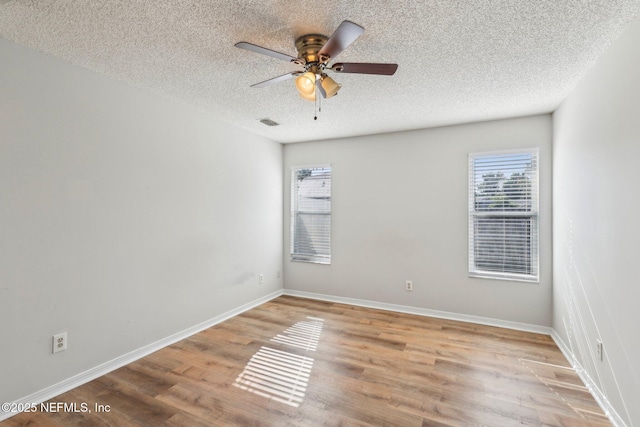 6085 Bermuda Dr, Fleming Island, FL 32003 - unfurnished room featuring a textured ceiling, a ceiling fan, wood finished floors, and baseboards