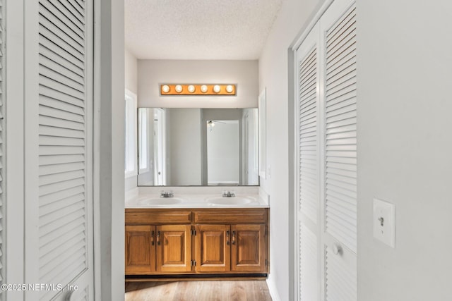 6085 Bermuda Dr, Fleming Island, FL 32003 - full bath with a closet, double vanity, a textured ceiling, and wood finished floors