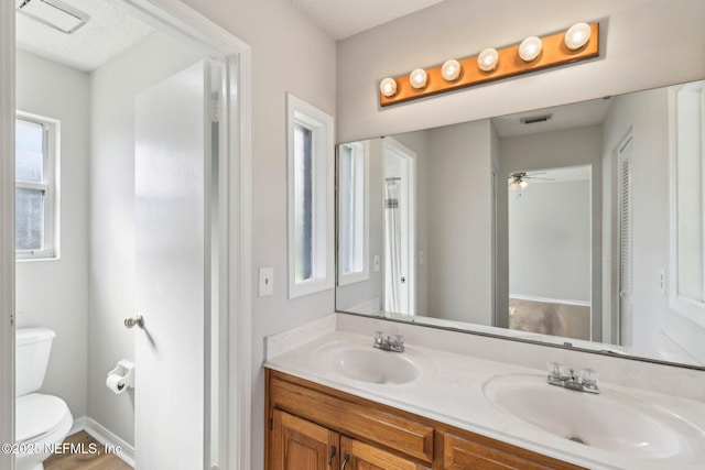 6085 Bermuda Dr, Fleming Island, FL 32003 - bathroom featuring toilet, double vanity, and a ceiling fan