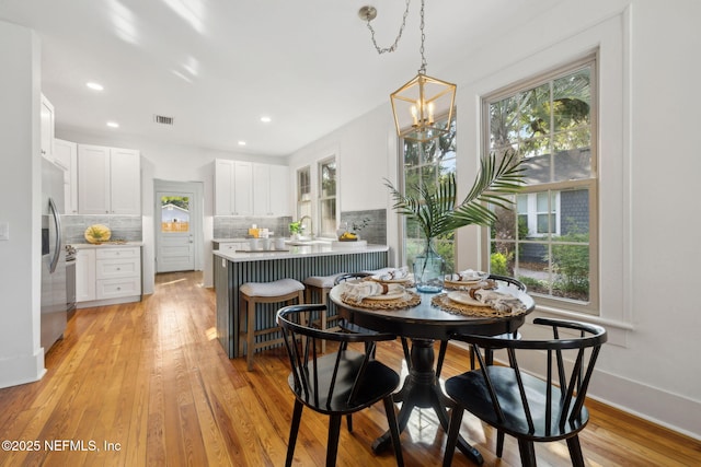 2930 Apache Ave, Jacksonville, FL 32210 - dining area with light wood-style floors, a chandelier, baseboards, and recessed lighting