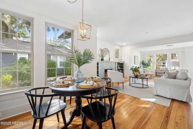 2930 Apache Ave, Jacksonville, FL 32210 - dining space with healthy amount of natural light, a brick fireplace, and light wood-style floors