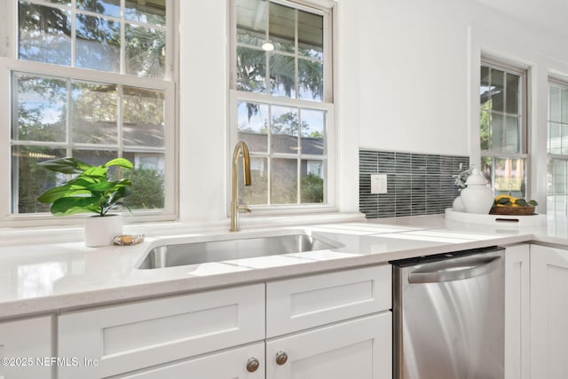 2930 Apache Ave, Jacksonville, FL 32210 - kitchen with dishwasher, a sink, white cabinetry, light stone countertops, and plenty of natural light