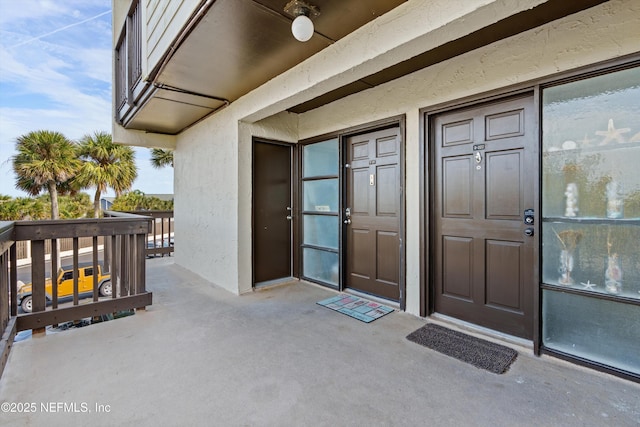 doorway to property with stucco siding and a balcony