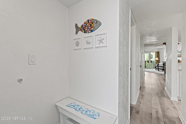hall with baseboards and light wood-type flooring