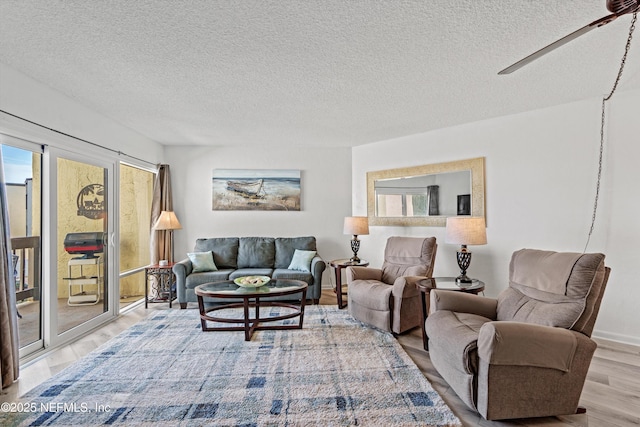 living area with a textured ceiling, ceiling fan, and wood finished floors