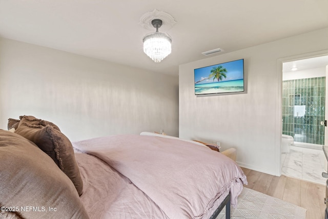 80 Boulder Ln, Saint Johns, FL 32259 - bedroom featuring light wood-style floors, a chandelier, connected bathroom, and baseboards