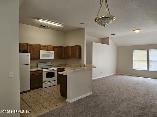kitchen with a peninsula, lofted ceiling, white appliances, open floor plan, and light countertops