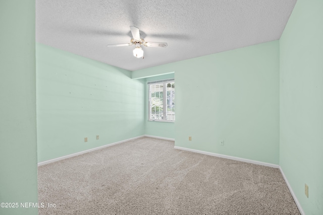 spare room featuring carpet floors, a ceiling fan, a textured ceiling, and baseboards