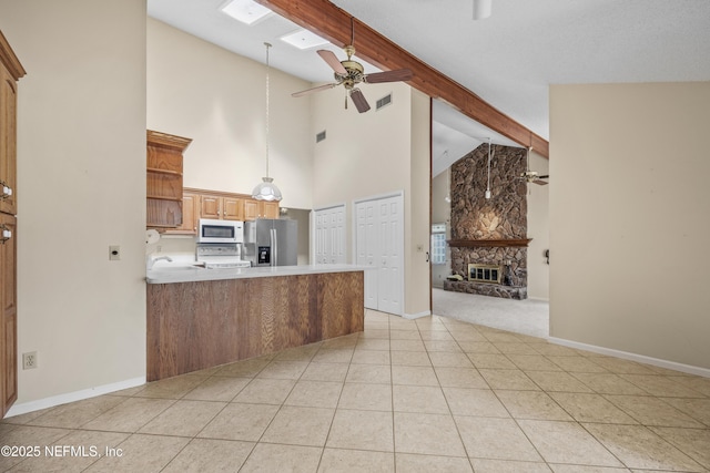 kitchen with a ceiling fan, stainless steel refrigerator with ice dispenser, range, high vaulted ceiling, and white microwave