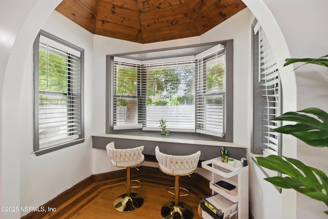 6878 Lenox Ave, Jacksonville, FL 32205 - living area featuring arched walkways, baseboards, wood finished floors, and lofted ceiling