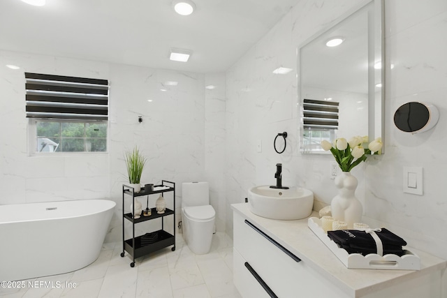 6878 Lenox Ave, Jacksonville, FL 32205 - full bath with vanity, toilet, marble finish floor, a freestanding tub, and tile walls