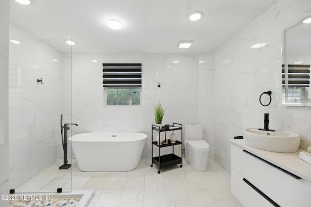 6878 Lenox Ave, Jacksonville, FL 32205 - bathroom with a freestanding bath, vanity, toilet, marble finish floor, and tile walls