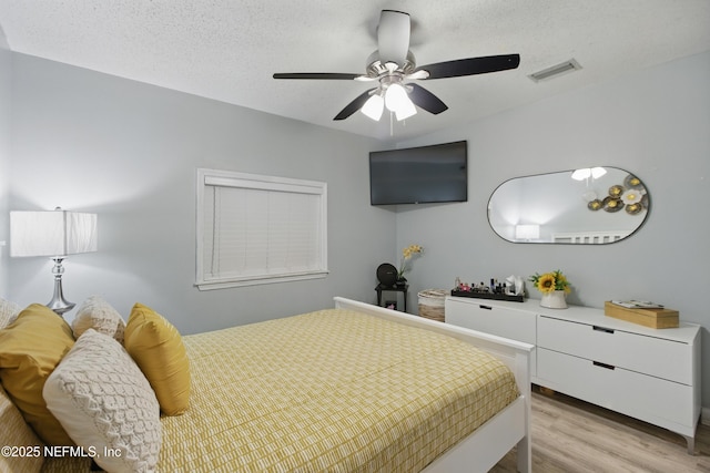 6878 Lenox Ave, Jacksonville, FL 32205 - bedroom with visible vents, a ceiling fan, a textured ceiling, and light wood-type flooring