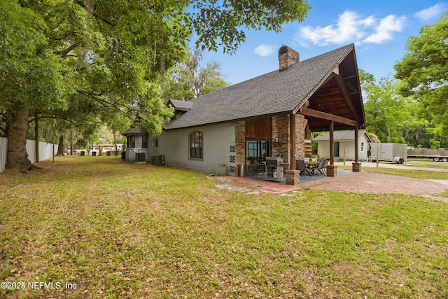 6878 Lenox Ave, Jacksonville, FL 32205 - view of property exterior with central air condition unit, a patio, a chimney, and a yard