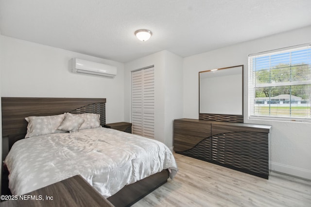 6878 Lenox Ave, Jacksonville, FL 32205 - bedroom with a closet, wood finished floors, baseboards, an AC wall unit, and a textured ceiling