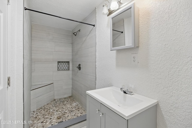 6878 Lenox Ave, Jacksonville, FL 32205 - full bathroom with a textured wall, a tile shower, and vanity