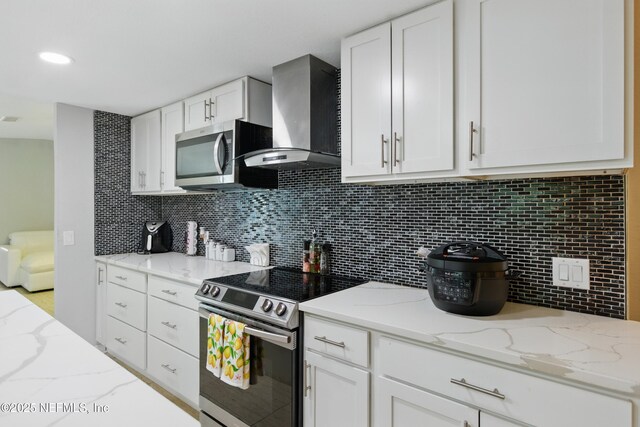 6878 Lenox Ave, Jacksonville, FL 32205 - kitchen with wall chimney range hood, stainless steel appliances, and white cabinetry